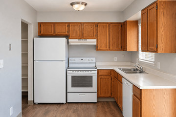 Westminster apartment for rent - A kitchen with wooden cabinets and white appliances.