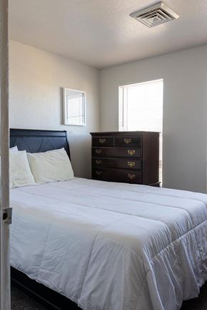 Greeley apartment for rent - A bedroom with a bed, dresser, and window at Meeker Commons, Greeley, CO, 80631