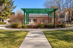 Westminster apartment for rent - A green pergola is situated in the middle of a grassy area with a concrete walkway leading to it.