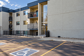 Arvada apartment for rent - A parking lot with a handicap parking space in front of a building.