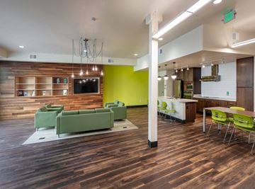 Denver apartment for rent - a living room with green couches and chairs and a kitchen