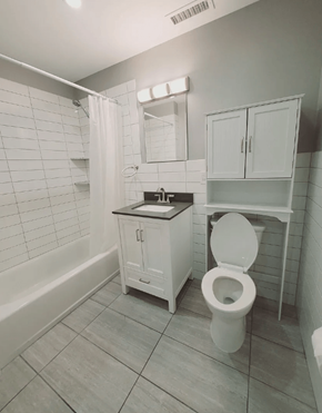 Stamford apartment for rent - A white toilet in a bathroom with a white cabinet and a white shower curtain.
