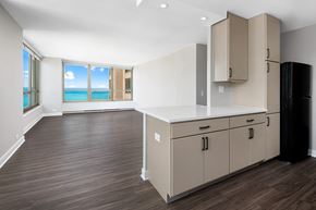 Chicago apartment for rent - A kitchen with a black refrigerator and wooden floors.
