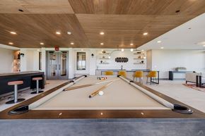 Del Valle apartment for rent - A pool table is in the middle of a room with a bar and a kitchen in the background.