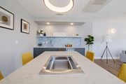 Pflugerville apartment for rent - A modern kitchen with a marble table and yellow chairs.