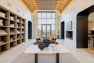Austin apartment for rent - A modern living room with a long table and a fireplace.