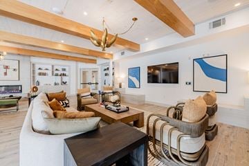 Sante Fe apartment for rent - A modern living room with a white sofa, a wooden coffee table, and a large abstract painting on the wall.