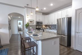 Frisco apartment for rent - A kitchen with a table set for two with a view of the refrigerator and oven.