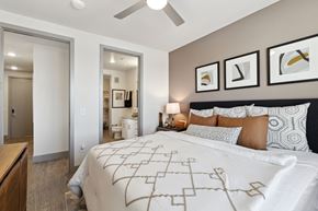 North Richland Hills apartment for rent - Apartment bedroom with ceiling fan, patterned bedding and neutral decor