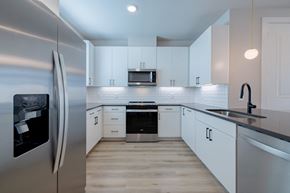 Austin apartment for rent - a kitchen with white cabinets and a stainless steel refrigerator