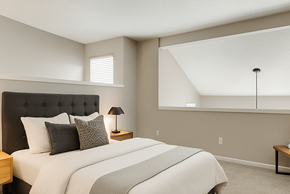 Dallas apartment for rent - A bedroom with a large bed and a nightstand with a lamp.