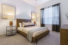 Sante Fe apartment for rent - A bedroom with a large bed and a painting on the wall.