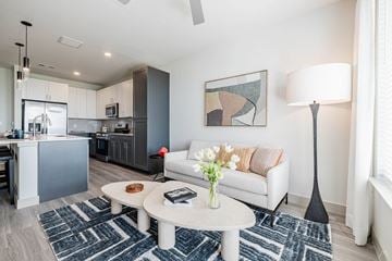 Del Valle apartment for rent - A modern living room with a white sofa, a coffee table, and a painting on the wall.