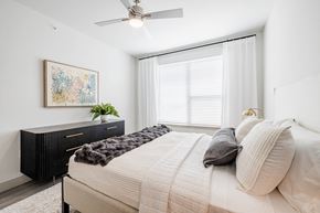 Del Valle apartment for rent - A bedroom with a large bed and a painting on the wall.
