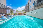 Pflugerville apartment for rent - A swimming pool with a waterfall feature in the middle.