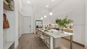 Frisco apartment for rent - an open kitchen with a marble counter top and a long island with chairs