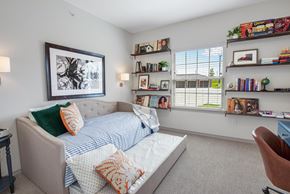 Frisco apartment for rent - A bedroom with a bed, a chair, and a bookshelf.