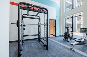 Austin apartment for rent - A gym with a squat rack and a bench press.
