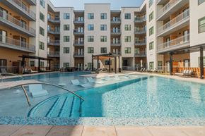 Farmers Branch apartment for rent - A large swimming pool in front of apartment buildings.