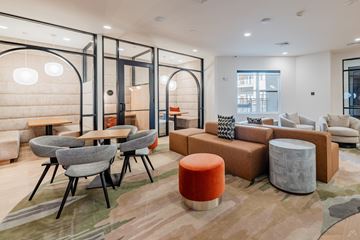 Farmers Branch apartment for rent - A modern living room with a grey sofa, a wooden table and a grey chair.
