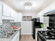 Dallas apartment for rent - A kitchen with black appliances and white cabinets.