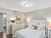 Dallas apartment for rent - A bedroom with a large bed, a dresser, and a painting on the wall.