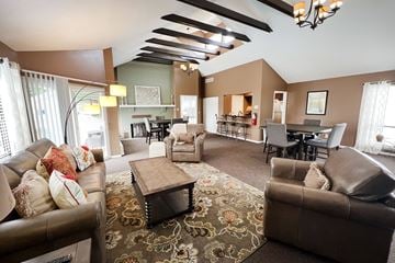Blue Ash townhouse for rent - A living room with brown leather furniture and a patterned rug.