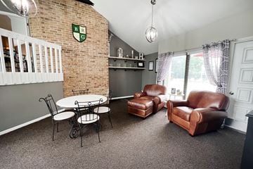 Blue Ash apartment for rent - a living room with leather chairs and a table and a brick wall