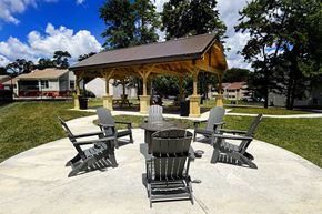Blue Ash townhouse for rent - A gazebo with four chairs and a table is surrounded by trees.