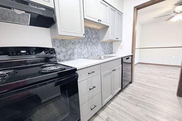 Ft. Mitchell apartment for rent - A kitchen with a black stove top oven and white cabinets.