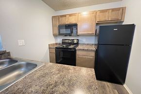 Galloway apartment for rent - a kitchen with stainless steel appliances and wooden cabinets at Eagle Crest Apartments, Galloway, OH 43119