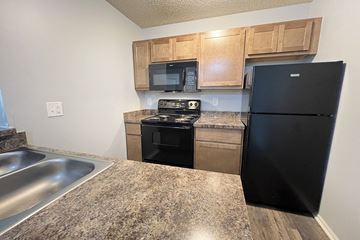 Galloway apartment for rent - a kitchen with stainless steel appliances and wooden cabinets