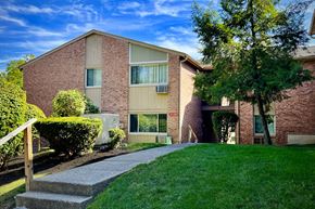 Hamilton apartment for rent - A red brick building with a green lawn in front.