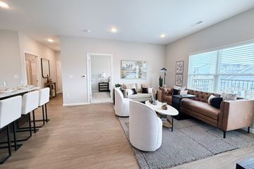 Batavia apartment for rent - A modern living room with white furniture and a large window.