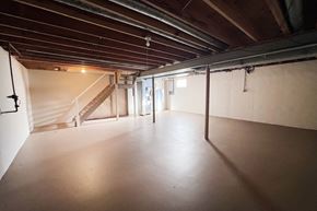West Chester triplex for rent - A spacious attic room with wooden beams and a staircase.