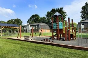 Amelia apartment for rent - A playground with a wooden swing set and a green slide.