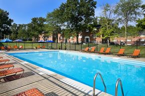 Cincinnati apartment for rent - a swimming pool with orange chairs and a fence around it at Sharondale Woods Apartments, Cincinnati