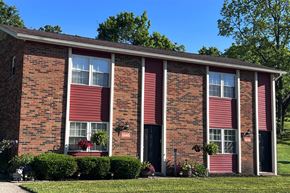 Cold Spring apartment for rent - A red brick house with a red door and a green lawn.