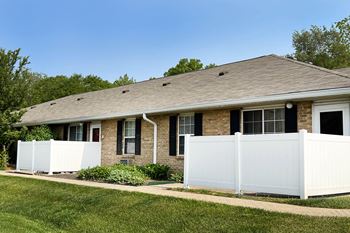 A house with a white fence in front of it