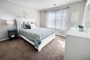 Georgetown triplex for rent - A bedroom with a large bed and a nightstand with a lamp.
