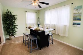 Cincinnati apartment for rent - an island with stools in a dining room with a ceiling fan at The Vinings Apartments, Cincinnati, OH