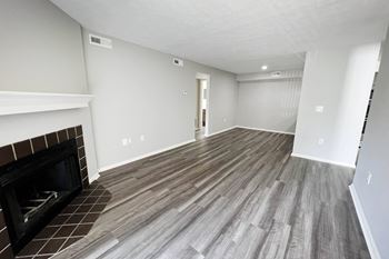 A living room with a fireplace and wooden floors