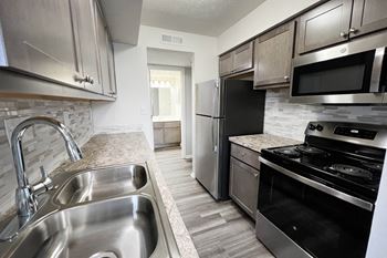 A kitchen with stainless steel appliances and granite counter tops