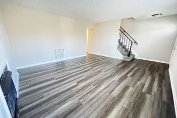 The living room and dining room of a home with wood flooring