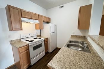 A kitchen with white appliances and granite counter tops