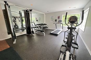 A gym with exercise equipment on the floor and a window