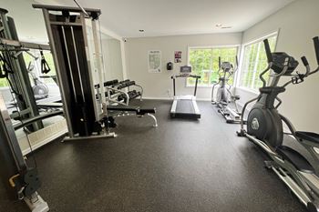 A gym with cardio machines and weights on the floor