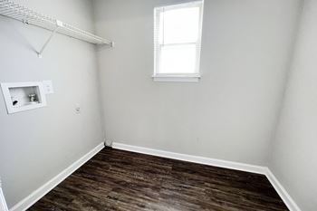 A small room with a wooden floor and a small window