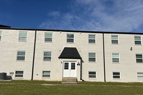 Frankfort townhouse for rent - A white building with a black roof and a white door in the center.