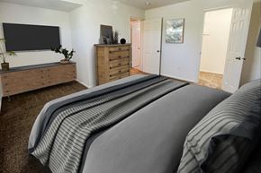 Centerville apartment for rent - the master bedroom has a large bed and a tvat Revere Village Apartments, Ohio, 45458